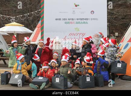 Seoul, Südkorea. 12. Dezember 2014. Kinder posieren für ein Foto mit Santa Claus in Seoul, Südkorea, 12. Dezember 2014. Weihnachtsmann aus Rovaniemi Finnland, die offizielle Heimat des Weihnachtsmannes, kam nach Südkorea die Wünsche von 20 Kindern aus armen Familien zu erfüllen. © Yao Qilin/Xinhua/Alamy Live-Nachrichten Stockfoto