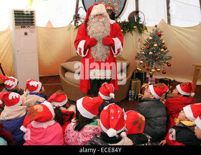 Seoul, Südkorea. 12. Dezember 2014. Santa Claus stellt sich Kinder in Seoul, Südkorea, 12. Dezember 2014. Weihnachtsmann aus Rovaniemi Finnland, die offizielle Heimat des Weihnachtsmannes, kam nach Südkorea die Wünsche von 20 Kindern aus armen Familien zu erfüllen. © Yao Qilin/Xinhua/Alamy Live-Nachrichten Stockfoto