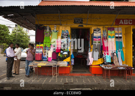 Mauritius, angezeigt Mahebourg, Central Market, Kleidung außerhalb Tante-Emma-Laden mit Männern außerhalb Stockfoto