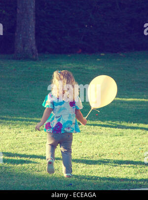 Mädchen, das mit einem Ballon durch den Park läuft, Buenos Aires, Argentinien Stockfoto
