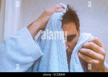 Mann, der aus dem Bad kommt und sein Haar mit einem Handtuch trocknet Stockfoto