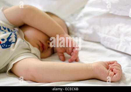 Babyjungen schlafen auf einem Bett Stockfoto