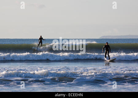 Surfer auf den Wellen im Saunton UK. Die Bucht in Nord-Devon ist beliebt bei Surfern und Boarder Stockfoto