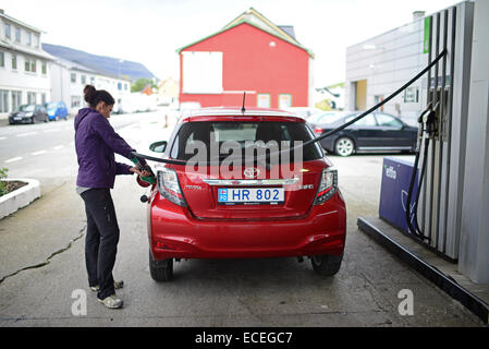 Junge Frau befüllen Tank des Autos in klaksvík, Färöer Inseln Stockfoto