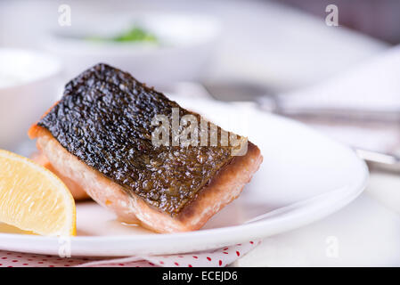 Gegrillte rote Fischfilet mit Zitrone und grünen Salat, Nahaufnahme, selektiven Fokus Stockfoto
