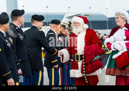 Mr. und Mrs. Santa Claus shake Hands mit militärischen Service-Mitglieder während einer Schneeball Express Abschiedszeremonie am O' Hare International Airport 11. Dezember 2014 in Chicago, IL.  Schneeball-Express ist eine gemeinnützige Organisation, die organisiert All-inclusive-Reise für Kinder und Ehegatten, die ein gefallenen militärischen Familienmitglied verloren haben. Stockfoto