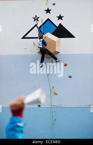 Bozeman, Mont., USA. 12. Dezember 2014. Kuhglocken und Hoppla aus der Masse anfeuern Bozeman Kletterer Justin Willis, wie er in der Mens Blei Aufstieg Bestandteil der internationalen Kletter- und Mountaineering Federation Ice Climbing World Cup in Bozeman, Mont., USA konkurriert. Veranstaltungen weiter bis Samstag. Stockfoto