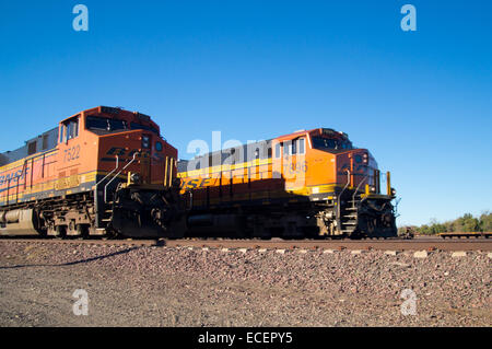 Markante orange und gelb Burlington Northern Santa Fe Lokomotive Güterzüge. 7522 und 7896 Auf die Tracks mit Nadeln Stockfoto