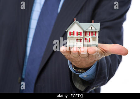 Nahaufnahme des männlichen Immobilienmakler ein Miniaturhaus in seiner Hand hielt. Stockfoto
