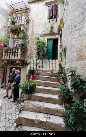 TROGIR, Kroatien - 19. Mai 2013: Ein paar mittleren Alters Touristen in eine Ecke typisch dalmatinischen Stadt Trogir, Kroatien am 13. Mai Stockfoto