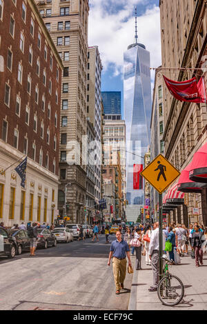 Eine belebte Straße in Downtown Manhattan ist in den Schatten gestellt von World Trade Center One, The Freedom Tower, New York City - USA. Stockfoto