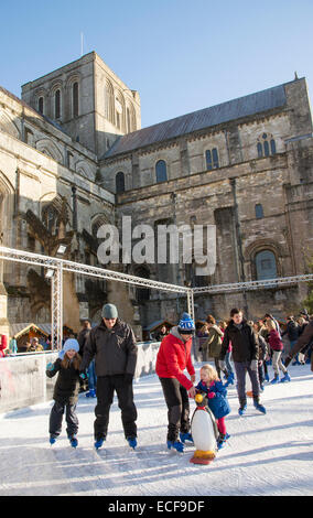 Weihnachten-Skater auf der Eisbahn an der Winchester Kathedrale Hampshire England UK Stockfoto