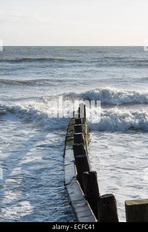 Wellen schlagen eine Buhne und dem Strand am Weststrand, drehte Littlehampton an einem Wintertag genauso wie die Flut Stockfoto