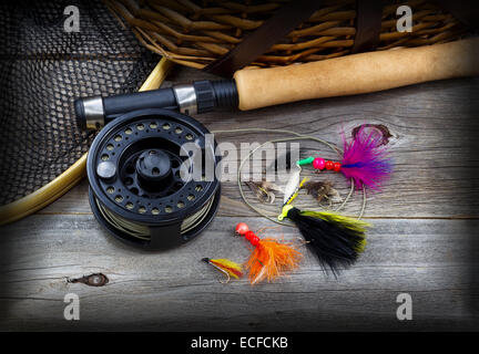 Draufsicht der Angeln Fly Reel, Kescher, Gatter hautnah und sortierte fliegen, teilweise Kork behandelt Pol auf urigen Holzbrettern Stockfoto