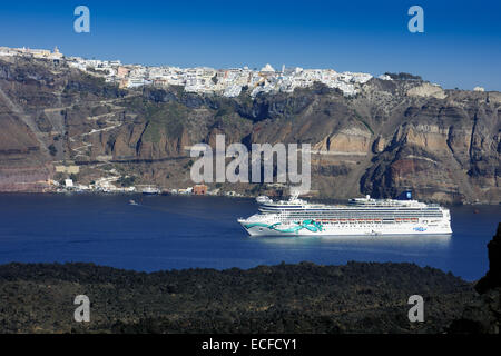 Kreuzfahrtschiff Norwegian Jade unter Klippen und weißen Häusern, Santorini, Griechenland Stockfoto