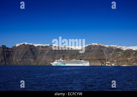 Kreuzfahrtschiff Norwegian Jade unter Klippen und weißen Häusern, Santorini, Griechenland Stockfoto