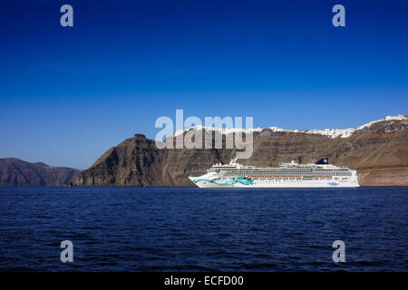 Kreuzfahrtschiff Norwegian Jade unter Klippen und weißen Häusern, Santorini, Griechenland Stockfoto