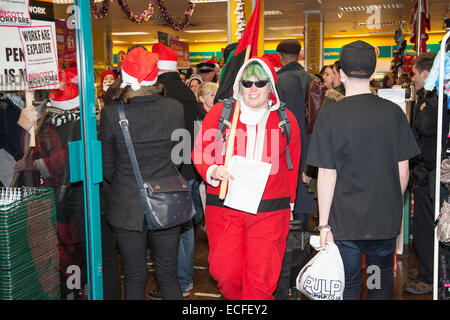 Bristol, UK. 13. Dezember 2014. Demonstranten verkleidet als Santa Protest gegen Workfare bei Poundland. Demonstranten besetzen den laden ihre eigene Version der Weihnachtslieder singen.   Workfare, wo Menschen auf Leistungen ohne Lohn arbeiten müssen, wurde von einigen großen Unternehmen unterstützt. Samstag, 13. Dezember 2014 Bristol, UK. Bildnachweis: Redorbital Fotografie/Alamy Live-Nachrichten Stockfoto