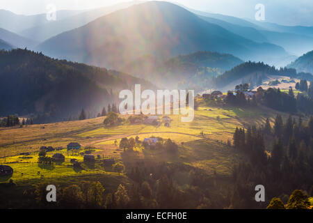 Wunderschönen Lichtstrahl Morgen mit Dorf am Bergtäler Stockfoto