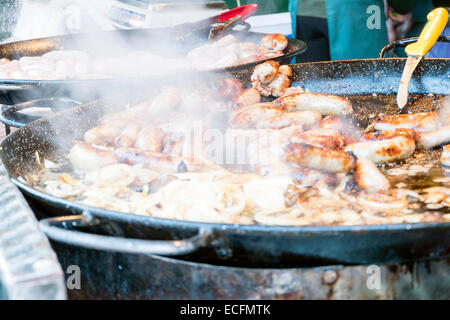 Würstchen & Zwiebeln Kochen in einer riesigen Pfanne schwenken, außerhalb catering, UK. Stockfoto
