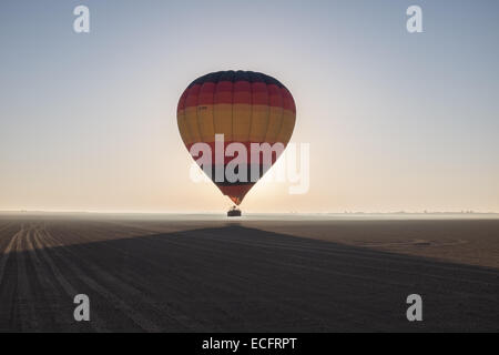 Heißluft-Ballon in der Wüste von Dubai bei Sonnenaufgang Stockfoto