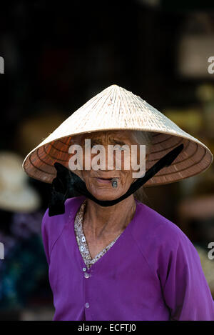 Vietnamesische Seniorin einen konischen Hut an ihrem Marktstand in Hue Stockfoto