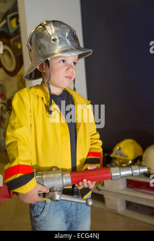 Niedlichen kleinen Jungen als Feuerwehrmann verkleidet Stockfoto