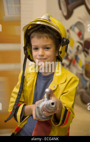 Niedlichen kleinen Jungen als Feuerwehrmann verkleidet Stockfoto