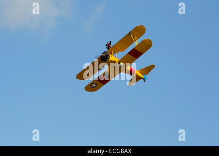 Boeing Stearman A75L 300 Kaydet G-CGPY im Flug über Breighton Flugplatz mit Flügel-Walker auf obere Tragfläche Stockfoto