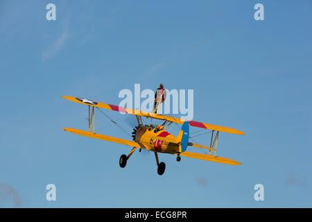 Boeing Stearman A75L 300 Kaydet G-CGPY im Flug über Breighton Flugplatz mit Flügel-Walker auf obere Tragfläche Stockfoto