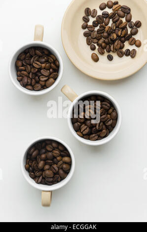 Kaffeebohnen in Tassen über weißen Tisch, über Ansicht Stockfoto