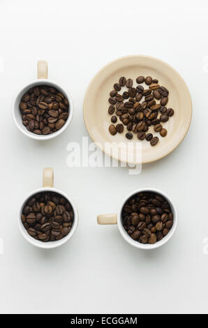 Kaffeebohnen in Tassen über weißen Tisch, über Ansicht Stockfoto