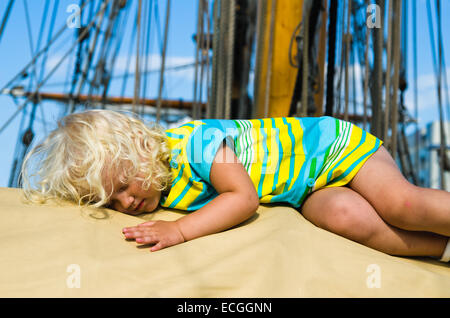 Das kleine Mädchen schlief auf dem Deck eines Segelbootes Stockfoto