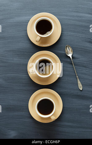 Kaffeetassen und einen Löffel über Kreide strukturierte Tisch, über Ansicht Stockfoto