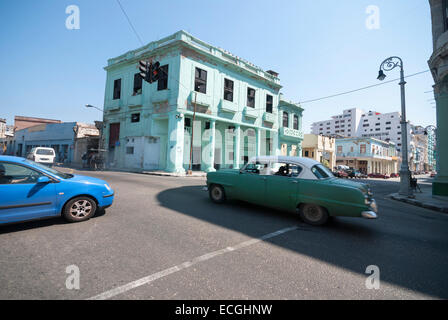 Zwei amerikanische Oldtimer Geschwindigkeit über eine Kreuzung in einem zentralen Viertel von Havanna. Stockfoto