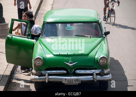 Ein Mann und eine Frau Ausstieg eines amerikanischen Oldtimers verwendet als Taxi auf dem Prado in der Nähe von Parque Centrale in Havanna Kuba. Stockfoto