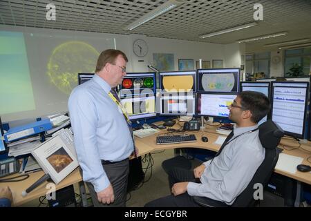 UK Met Office - Mark Seltzer, Senior Operations Wettervorhersage in Wetter Raumfahrtzentrum mit Sonne auf Bildschirmen hinter Rede vor Ort Stockfoto