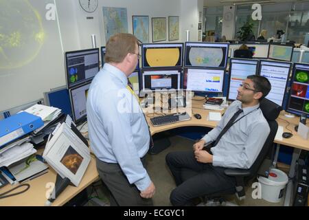 UK Met Office - Mark Seltzer, Senior Operations Meteorologe in Wetter Raumfahrtzentrum mit Sonne vor Ort auf Bildschirme hinter Stockfoto