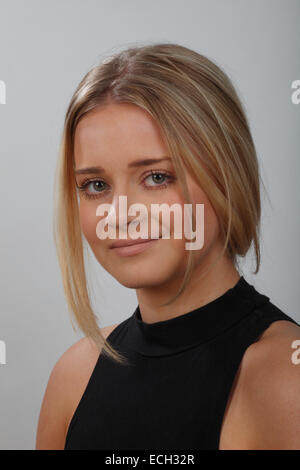 Kopfschuss oder Porträt einer jungen blonden Frau mit grünen Augen, tragen ein schwarzes Top und ihr Haar oben. Stockfoto