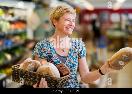 Die bessere Food Company Bio Supermarkt in St. Werburgh es, Bristol UK - Lucy Gatward, Marketing Manager Nachfüllen Brot b Stockfoto