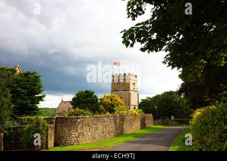 Eine Kirche mit einem gedrungenen Turm und eine Flagge, die in einen Feldweg. Stockfoto
