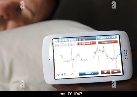 Mann schläft während seiner ECG mit einem Custo Kybe Pulsmesser überwacht. Stockfoto