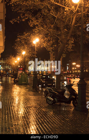 Nass und regnerisch Straßen von Valencia in der Nacht mit Straßenlaternen und Reflexionen Stockfoto