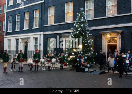 London, UK. 15. Dezember 2014. Kinder erhalten ein Genuss, wie sie Downing Street für eine Weihnachtsfeier besuchen, wenn sie von Rentier am Eingang Nummer 10 begrüßt werden. Bildnachweis: Paul Davey/Alamy Live-Nachrichten Stockfoto