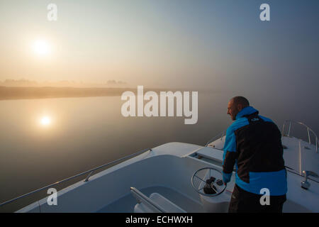 Person, die Navigation von einem Kreuzfahrt-Schiff über Lough Ree im Morgengrauen, Fluss Shannon, County Westmeath, Irland. Stockfoto