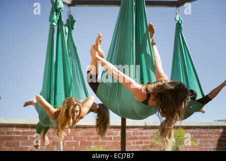 Eine Frau nimmt Bogen Pose während der Durchführung aerial Yoga. Stockfoto