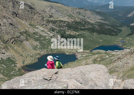 Junge-Mädchen-Zwillinge sitzen auf einem Aussichtspunkt auf 14.000 Fuß Mount Evans. Stockfoto