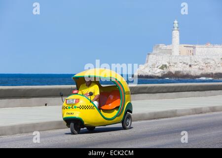 Kuba, La Habana, Coco-Taxi auf dem Malecon und Castillo de Los Tres Reyes Magos del Moro im Hintergrund Stockfoto