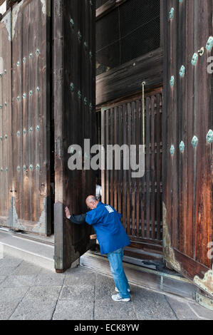 Der Hüter schließt die riesigen Holztüren der Großen Buddha-Halle (Daibutsuden) im Todai-JI-Tempel in Nara, Japan Stockfoto