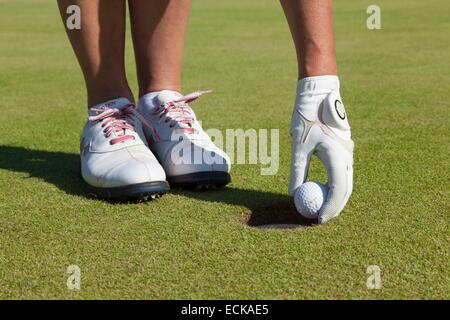 Frankreich, Pas-De-Calais, Hardelot, Golf-Kiefer, Frau Abholung einen Golfball Stockfoto